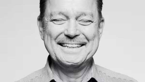 Foto: Marcel Grümmer lächelt über das ganze Gesicht und schließt dabei die Augen.