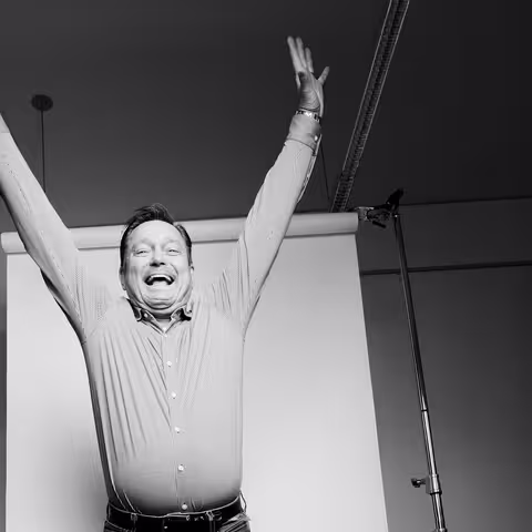 Foto: Marcel Grümmer macht einen Luftsprung und hebt dabei die Arme über den Kopf.