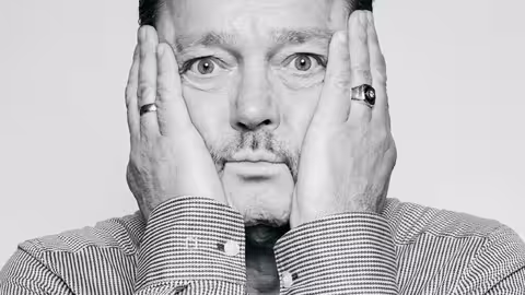 Foto: Marcel Grümmer schaut offen in die Kamera und legt seine Handflächen an die Wangen.