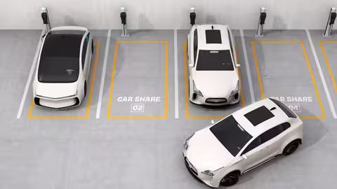 Mehrere Carsharing-Fahrzeuge stehen auf markierten Parkplätzen mit Ladestationen.