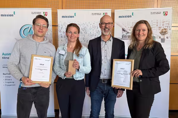 Vier Mitarbeiterinnnen und Mitarbeiter des Bau- und Liegenschaftsbetriebs halten die beiden Urkunden und die Auszeichnung in die Kamera.