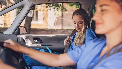 Foto: Zwei Kolleginnen teilen sich eine Autofahrt zur Arbeit.