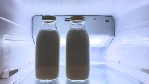 Foto: zwei Milchflaschen in einem bläulich beleuchteten Kühlschrank