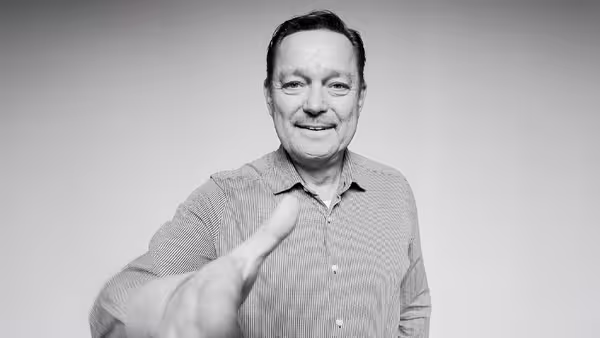 Marcel Grümmer streckt freundlich seine Hand in Richtung der Kamera aus.