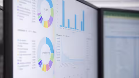 Foto: Nahaufnahme von zwei sehr hell eingestellten Monitoren mit Diagrammen und Tabellen