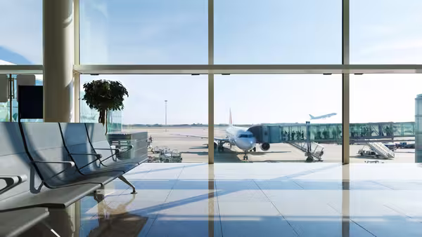 Foto: Blick aus einem Flughafen-Terminal auf das Vorfeld und die Startbahn