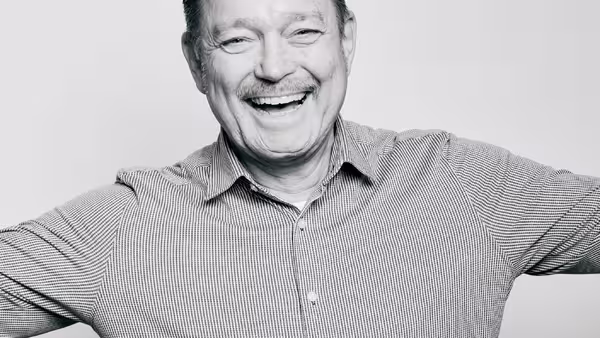 Foto: Marcel Grümmer lacht und breitet einladend die Arme aus.