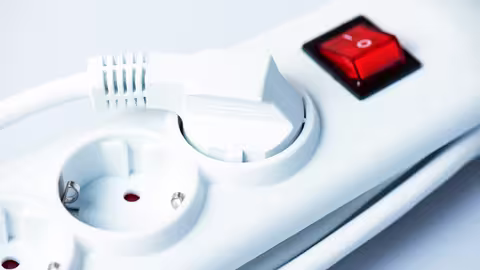 Foto: eine weiße Mehrfachsteckdose mit rotem Ausschalter