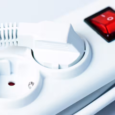 Foto: eine weiße Mehrfachsteckdose mit rotem Ausschalter