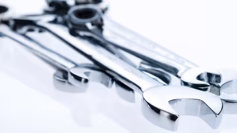 Foto: Nahaufnahme von mehreren übereinander liegenden Schraubenschlüssel aus glänzendem Edelstahl