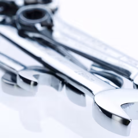 Foto: Nahaufnahme von mehreren übereinander liegenden Schraubenschlüssel aus glänzendem Edelstahl