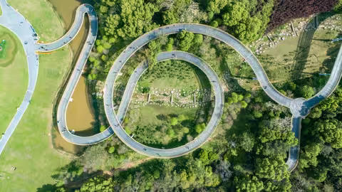 Foto aus der Vogelperspektive: grüner Wald in einem Park mit kreisförmig gewundenem Bergwanderweg