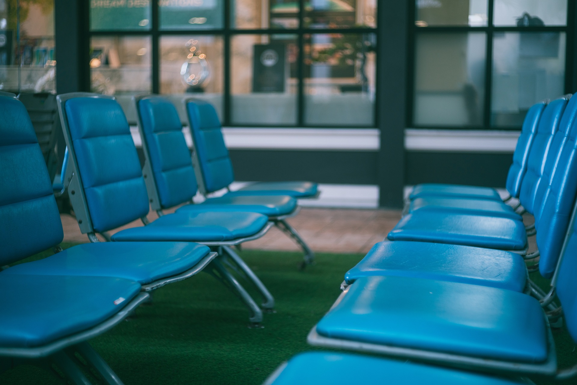 leere hellblaue Stühle an einem Flughafen-Gate