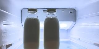 zwei Flaschen Milch im obersten Regal eines Kühlschranks