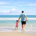ein Vater mit seiner kleinen Tochter an der Hand am Strand